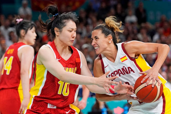Spain small forward Queralt Casas (9) drives to the basket against People's Republic of China forward Ru Zhang (10) in womenÕs basketball group A play during the Paris 2024 Olympic Summer Games at Stade Pierre-Mauroy.